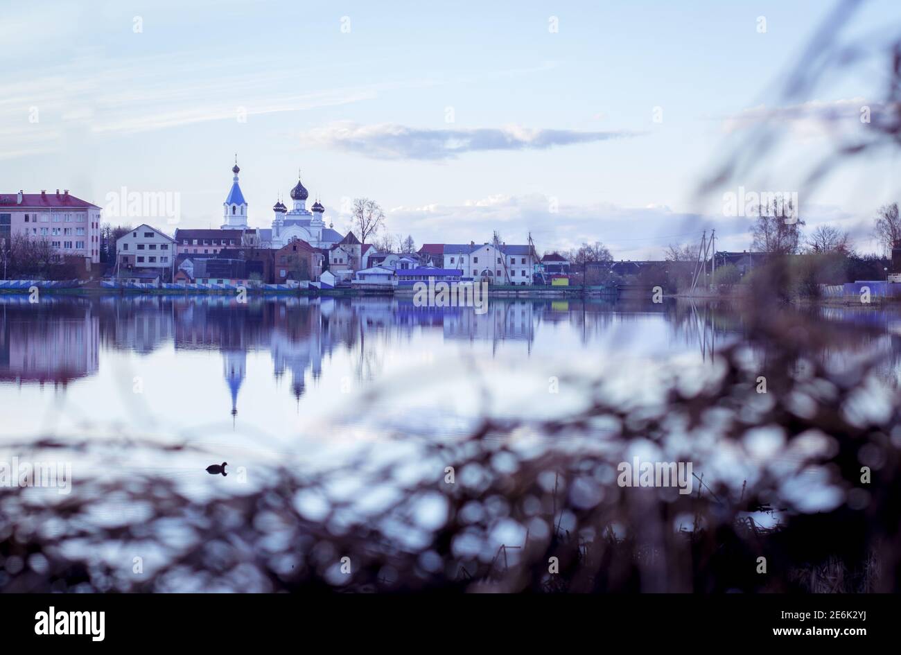Foto vom Ufer des Flusses, auf dem anderen Ufer können Sie die Kirche und die Stadt sehen Stockfoto