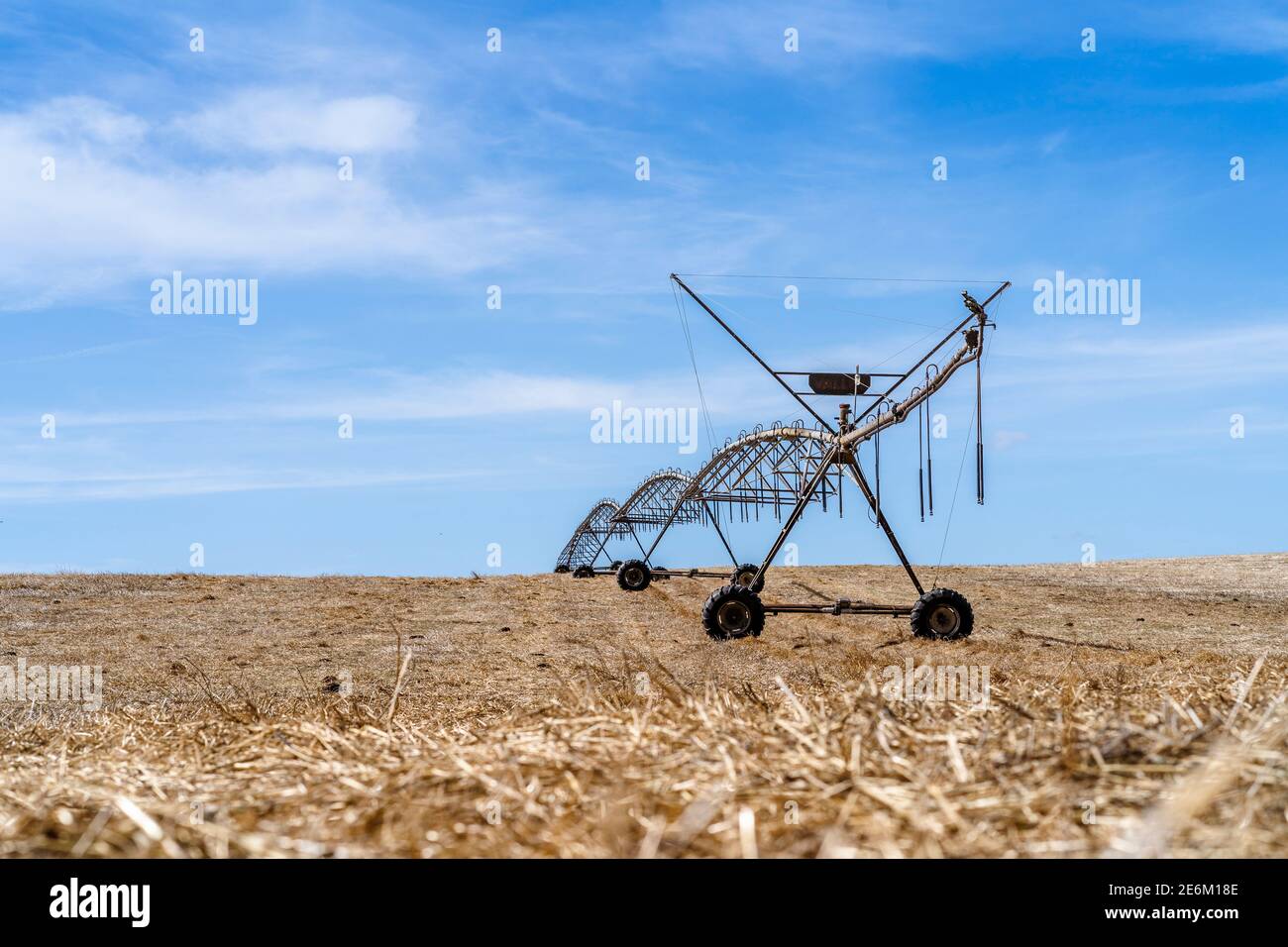 Bewegliches Bewässerungssystem auf einem trockenen Stoppelfeld in Alentejo, Portugal Stockfoto