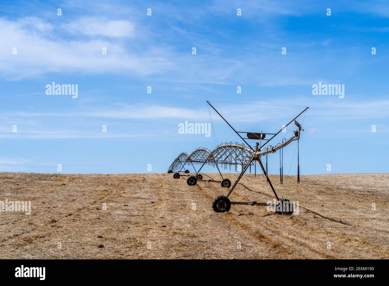 Bewegliches Bewässerungssystem auf einem trockenen Stoppelfeld in Alentejo, Portugal Stockfoto
