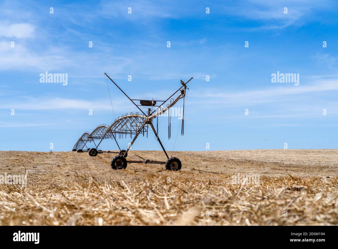 Bewegliches Bewässerungssystem auf einem trockenen Stoppelfeld in Alentejo, Portugal Stockfoto