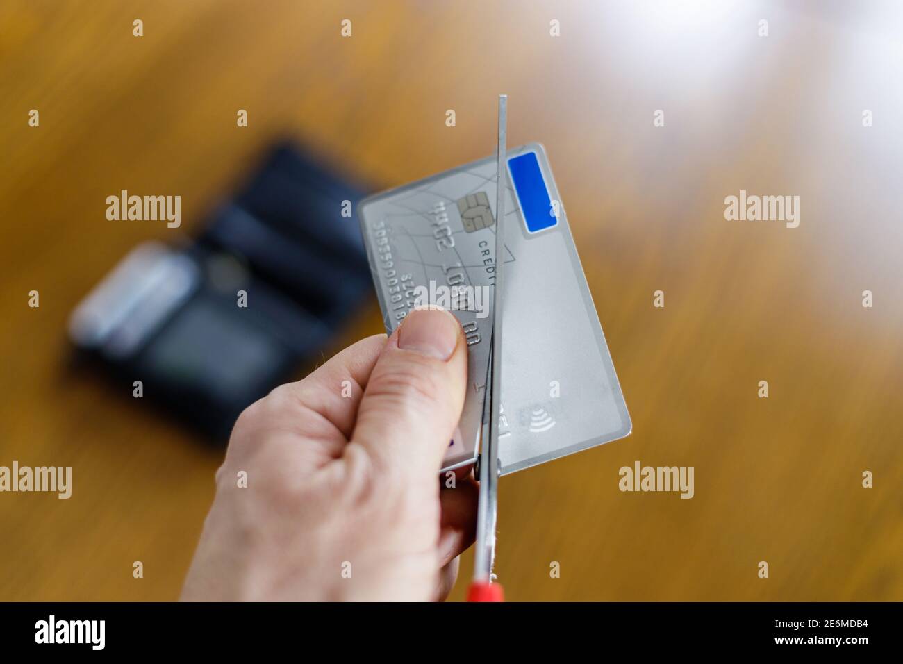 Irreversible Zerstörung einer deaktivierten Zahlungskarte durch Schneiden mit Schere Stockfoto