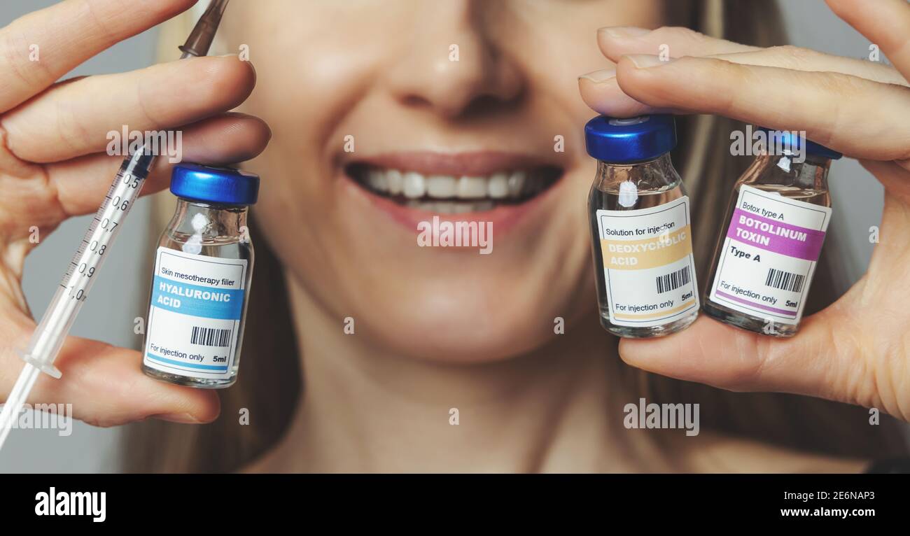 Lächelnde Frau mit kosmetischen Injektionsfläschchen und Spritze in den Händen. Anti-Aging nicht chirurgische Behandlungen Stockfoto