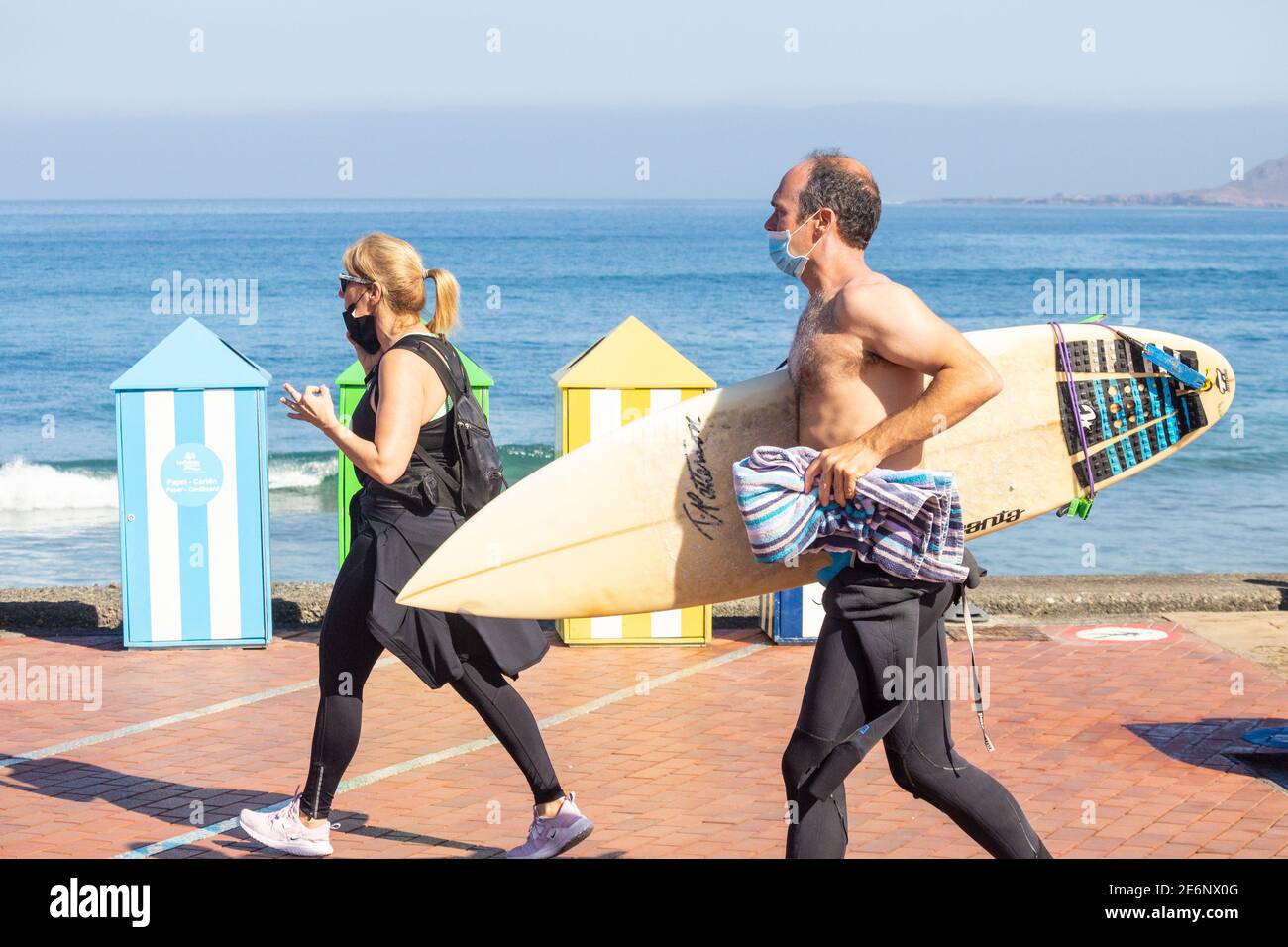 Surfer trägt Gesichtsmaske während Coronavirus, Covid 19 Pandemie in Spanien Stockfoto