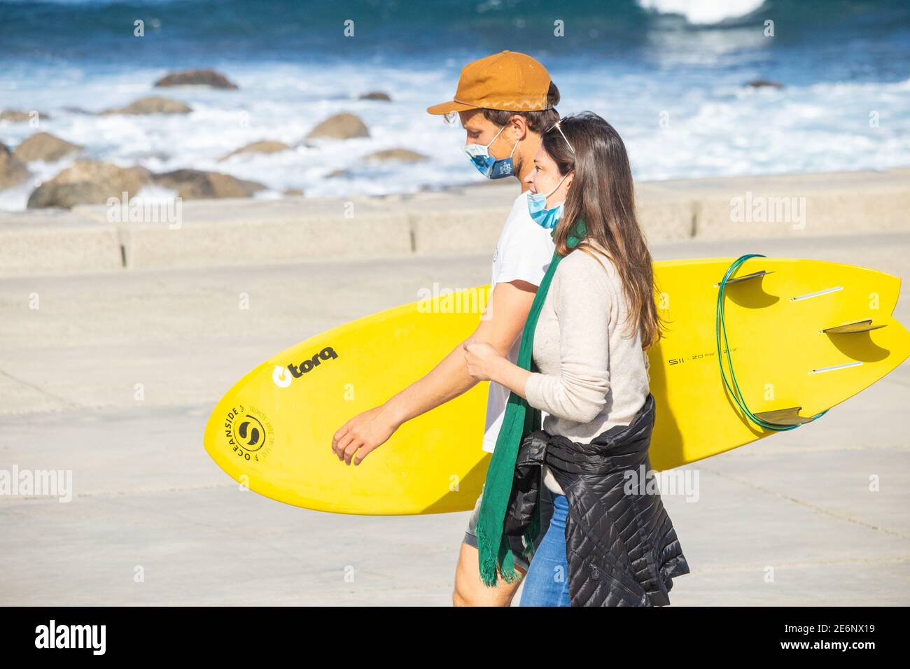 Surfer trägt Gesichtsmaske während Coronavirus, Covid 19 Pandemie in Spanien Stockfoto