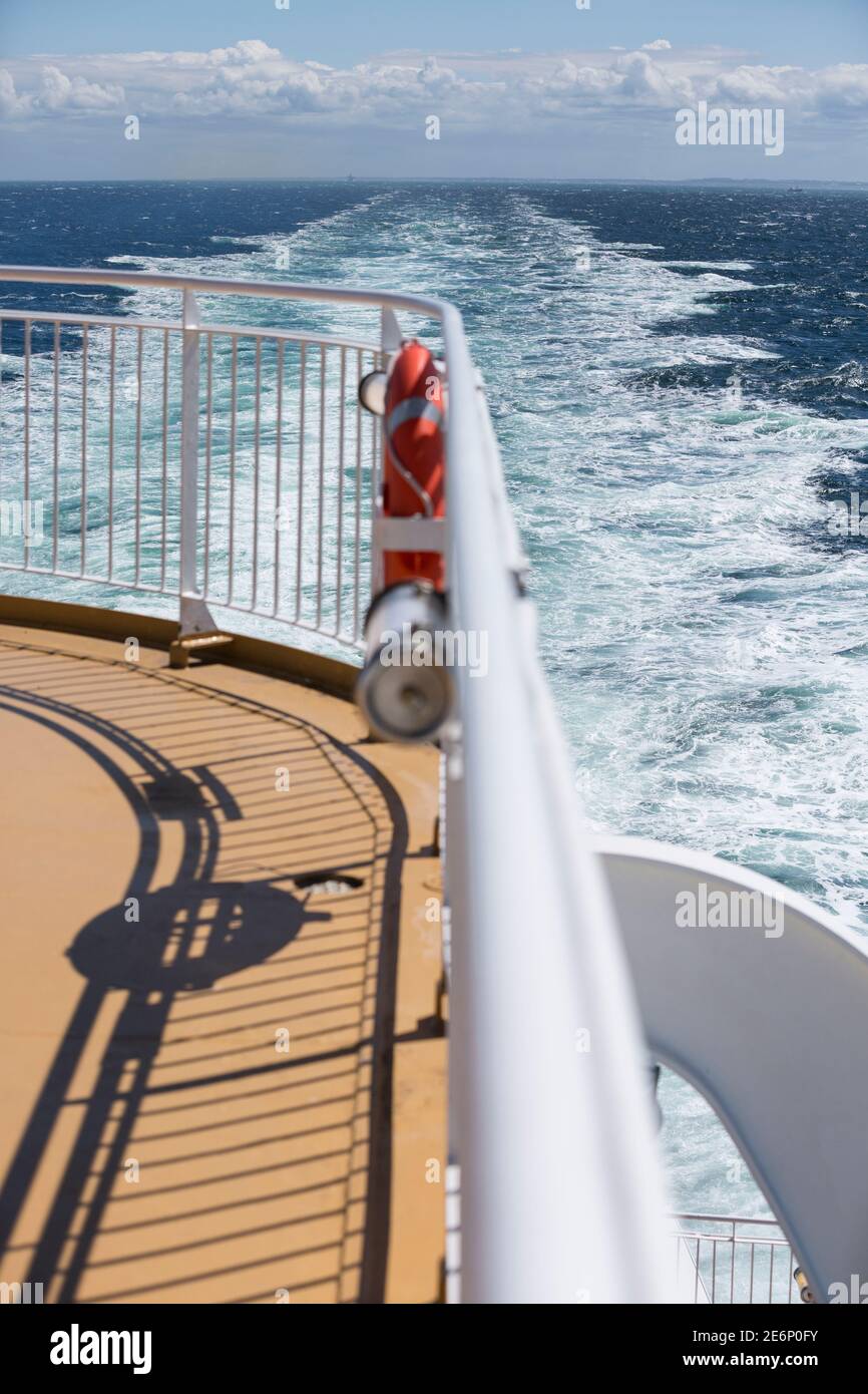 Gelbes Deck und weißer Handlauf mit krachenden Wellen an der Seite - Kreuzfahrt an Bord einer modernen Fähre zwischen Hirtshals, Dänemark und Kristiansand, Norwegen Stockfoto