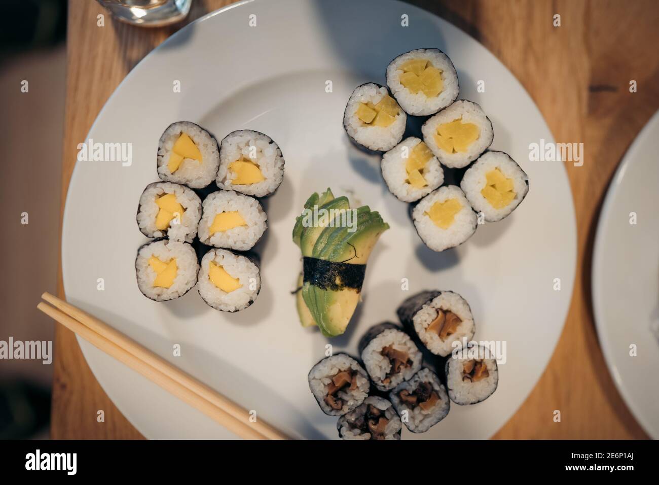 Set aus Sushi-Brötchen, Soße, Wasabi und Hand mit Essstäbchen auf dunklem Hintergrund. Draufsicht. Flach liegend. Japanisches Essen Stockfoto