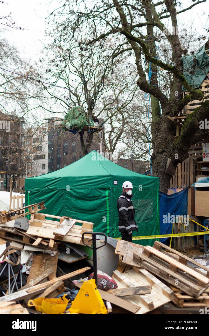 Räumung von Stop HS2 Demonstranten vom Campingplatz in Euston Square Gardens, London, 27. Januar 2021. Ein Mitglied des Räumungsteams steht zwischen Lagerschutt. Stockfoto