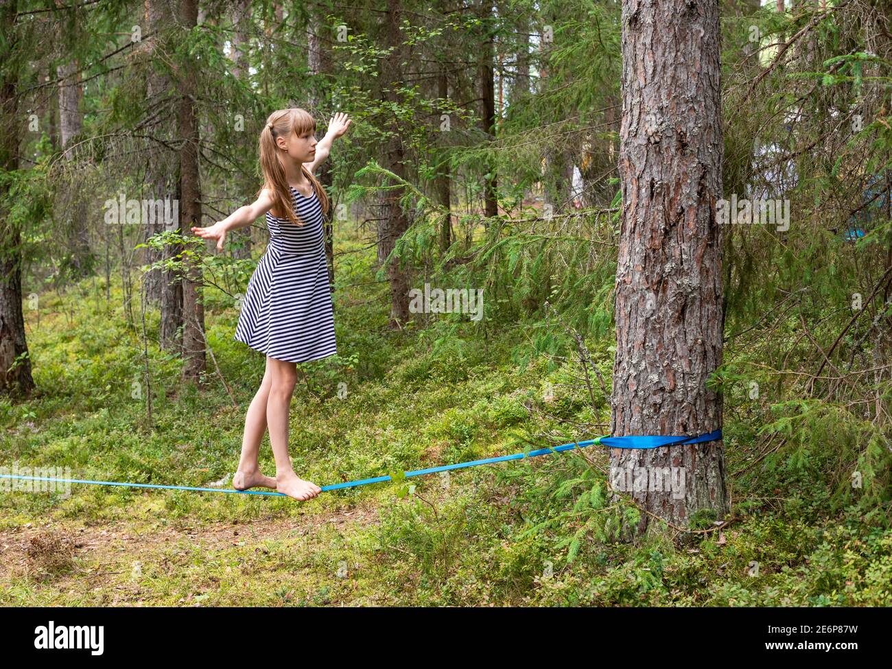 Zwischen Mädchen, die in den Sommerferien auf Slackline balancieren Stockfoto
