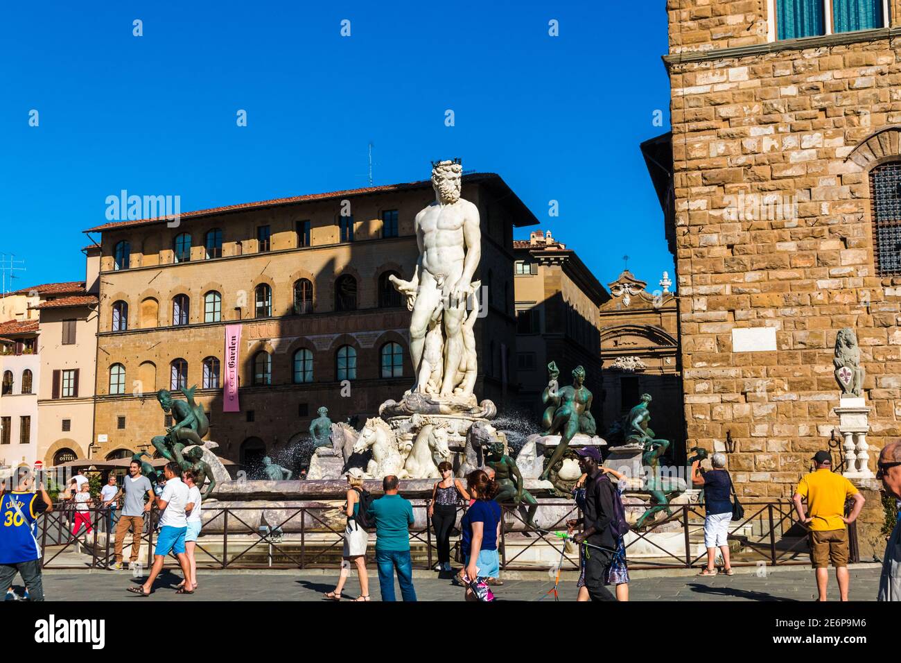 Schöner Blick auf die Menschen, die den beliebten Skulpturenbrunnen Neptun auf der Piazza della Signoria neben dem Palazzo bewundern und fotografieren... Stockfoto