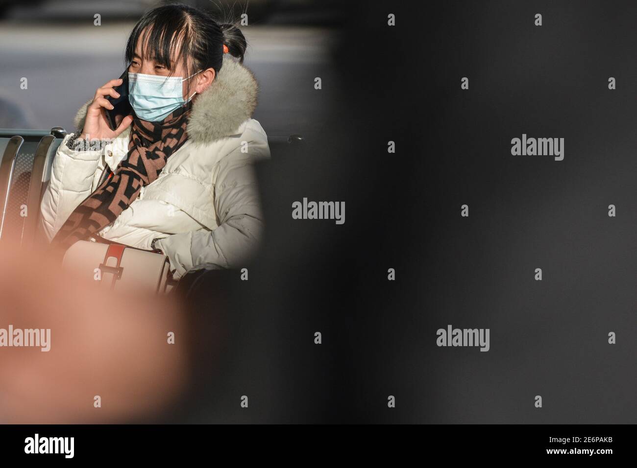 Fuyang, China. Januar 2021. Eine Fahrerin wartet am Telefon, bevor sie ihren Zug am Bahnhof von Fuyang nimmt.als die Reisestrequenz des Frühlingsfestes begann, haben die Transportunternehmen die Maßnahmen verschärft, um das Wiederaufleben von COVID-19 (Coronavirus) Fällen zu verhindern, indem sie die Gesichtsmask für alle Passagiere im Bahnhof obligatorisch machen. Rund 1.15 Milliarden Passagierfahrten wurden während der 40-tägigen Reiseansturm erwartet, ein Rückgang gegenüber dem Vorjahr von 20 Prozent und mehr als 60 Prozent weniger als im Jahr 2019 nach Angaben des Ministeriums. Kredit: SOPA Images Limited/Alamy Live Nachrichten Stockfoto