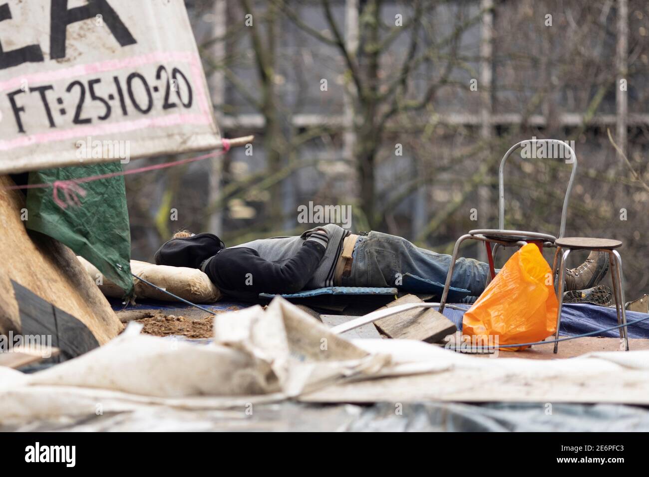 Räumung von Stop HS2 Demonstranten vom Campingplatz in Euston Square Gardens, London, 27. Januar 2021. Ein Protestler schläft auf dem Dach der Hütte im Lager Stockfoto