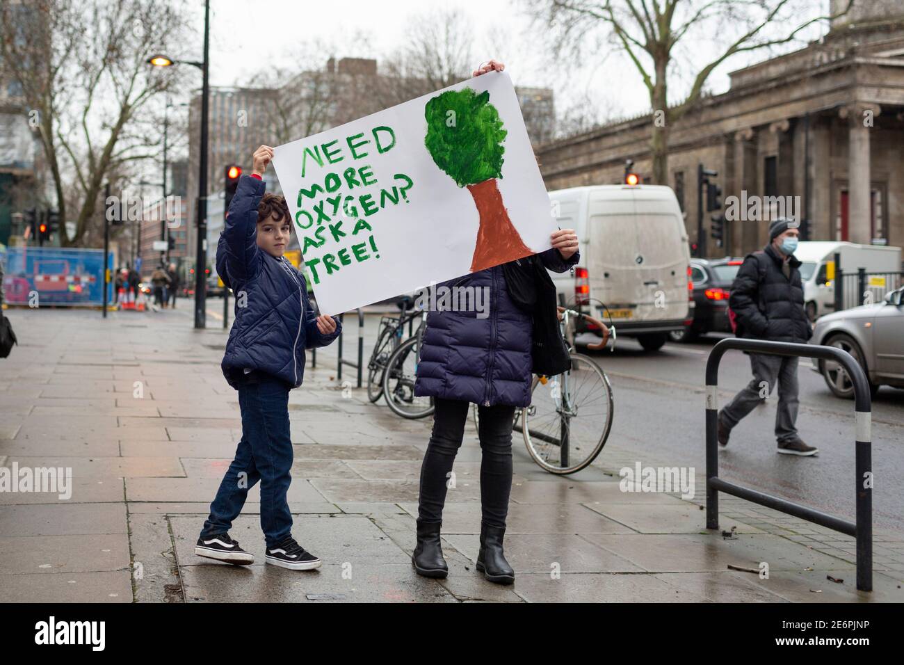 Räumung von Stop HS2 Demonstranten vom Campingplatz in Euston Square Gardens, London, 27. Januar 2021. Umstehende halten solidarisch ein Plakat hoch. Stockfoto