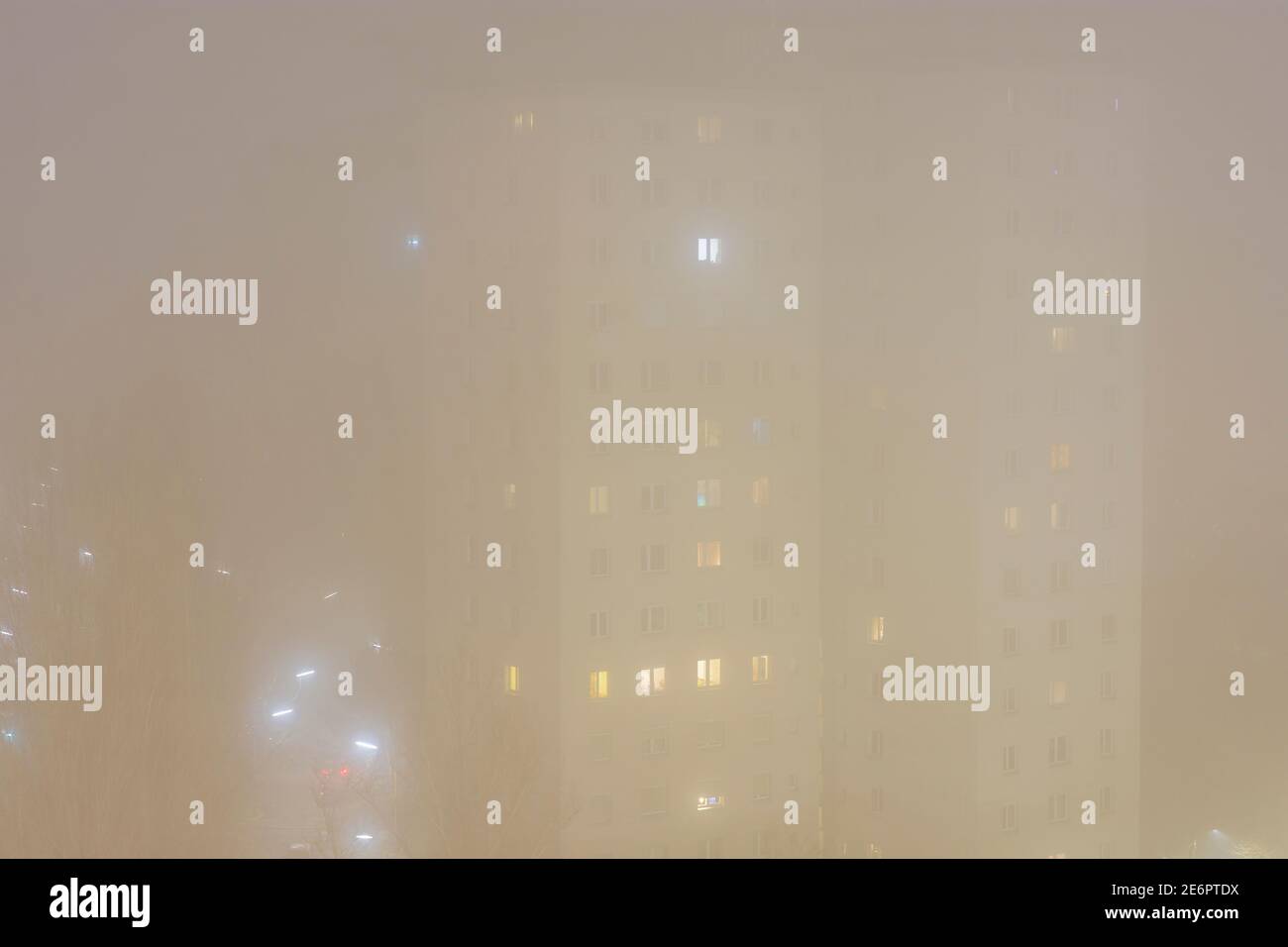 Wien, Wien: Nebel, Mehrfamilienhaus, Lichter in Räumen im Jahr 22. Donaustadt, Wien, Österreich Stockfoto