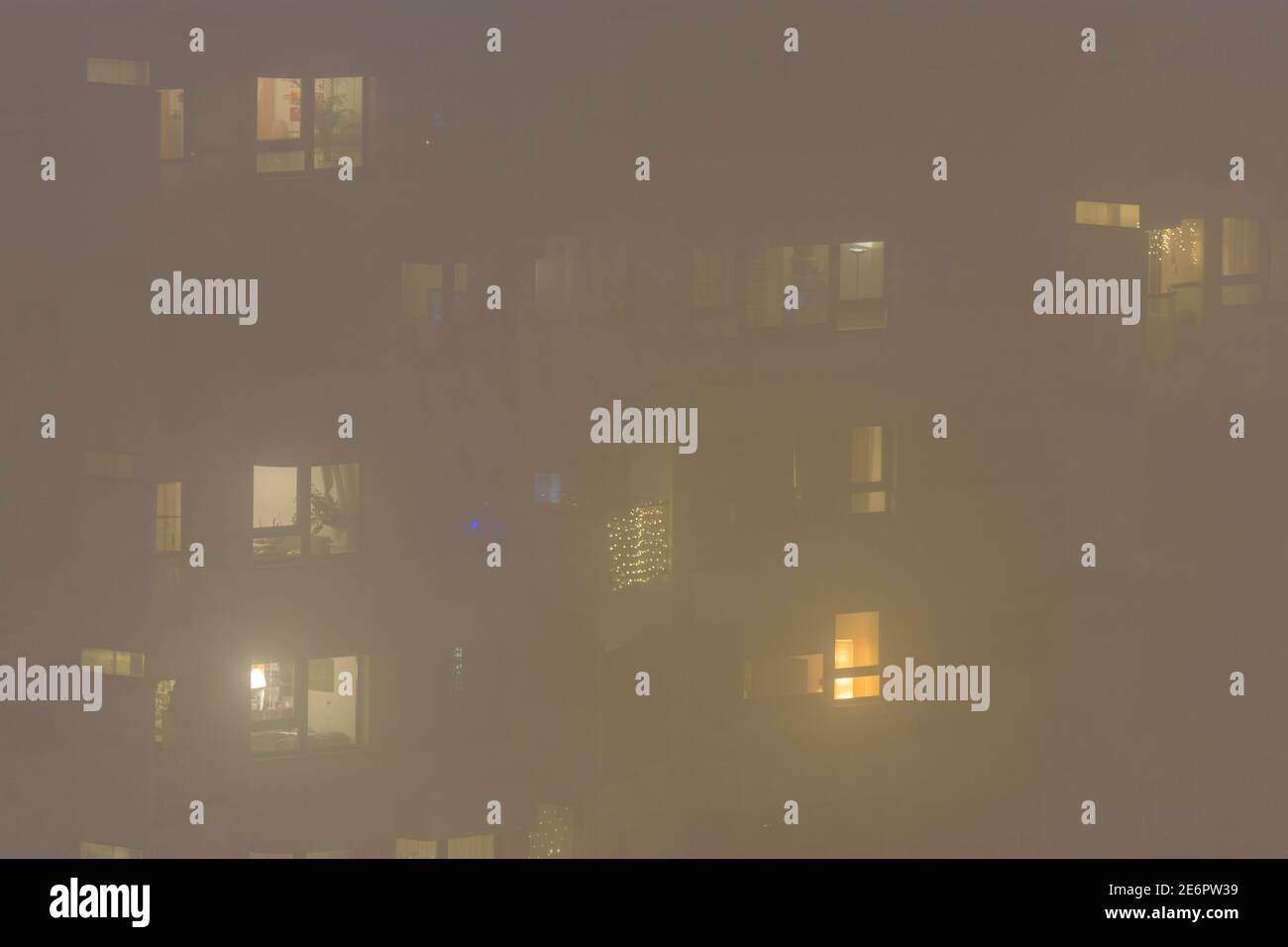 Wien, Wien: Nebel, Mehrfamilienhaus, Lichter in Räumen im Jahr 22. Donaustadt, Wien, Österreich Stockfoto