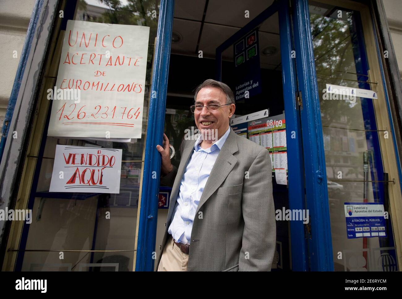 Agustin Marcos, Angestellter der Black Cat-Lotto-Kiosk im Zentrum von  Madrid, lächelt neben einem Schild mit der Aufschrift "Alleiniger Sieger  von Euro Millions 126.231.764" in Madrid 9. Mai 2009. Ein Lotto-Spieler in  Spanien