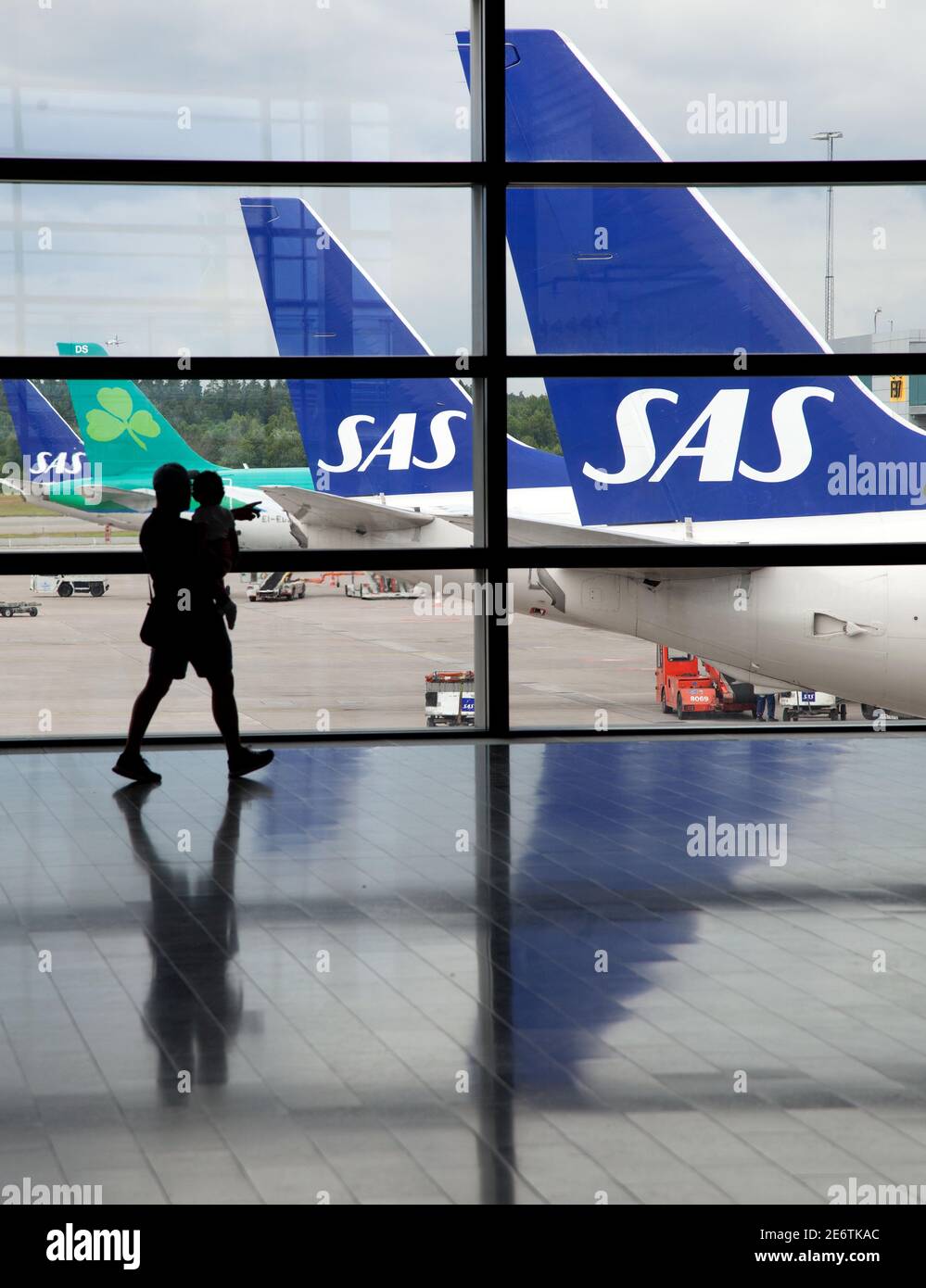 ARLANDA, SCHWEDEN - 30. JUNI 2013:Flugreisende am Flughafen Arlanda, Terminal 5. Im Hintergrund Flugzeuge der Fluggesellschaft SAS, skandinavische Fluggesellschaften. Stockfoto