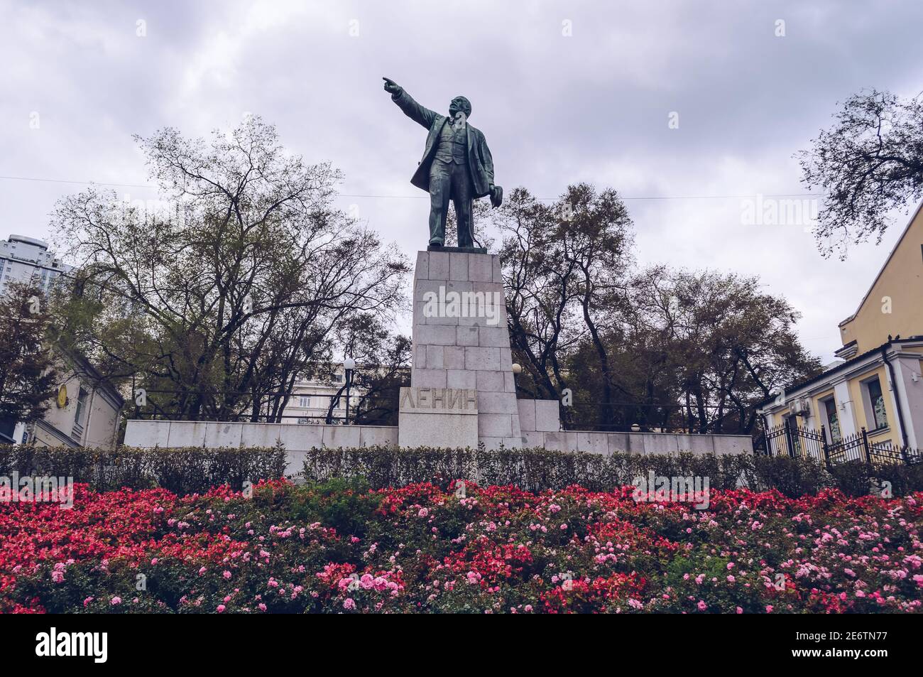 Wladiwostok, Russland - 05. Oktober 2020: Nahaufnahme der Skulptur Lenins mit Blumenbeet voller blühender Blumen Stockfoto
