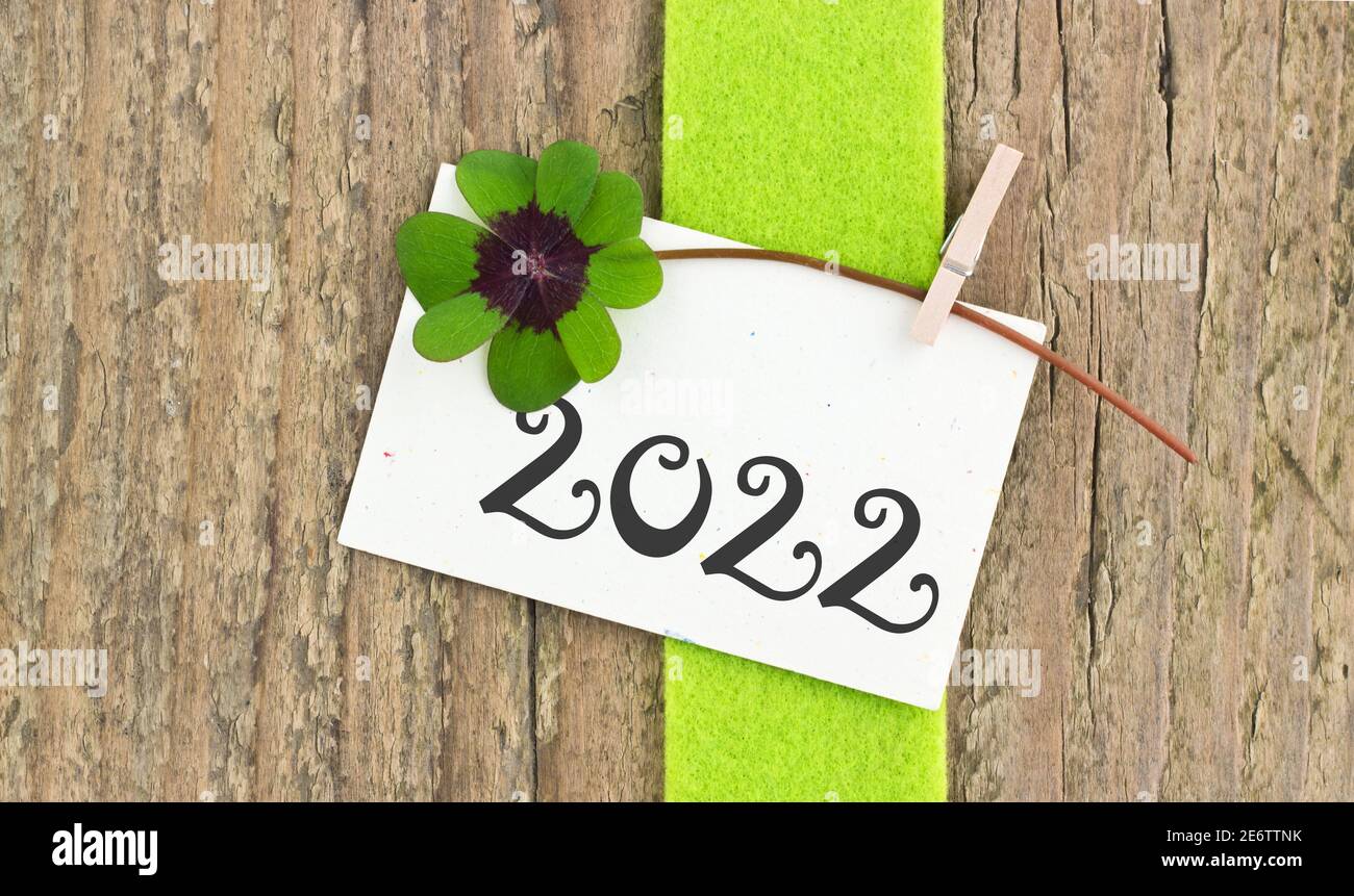 Neujahrskarte für das Jahr 2022 mit Kleeblatt Auf Holzhintergrund Stockfoto