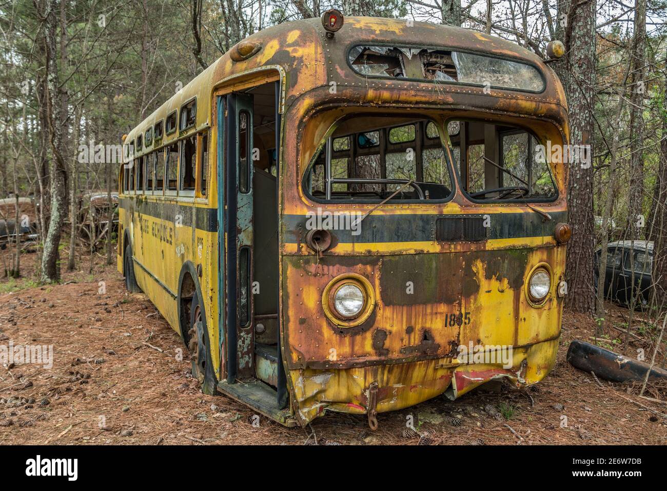 Leerer Vintage alter rostiger Schulbus der 50er Jahre, der im Freien verlassene Der Wald zum Verfall Stockfoto