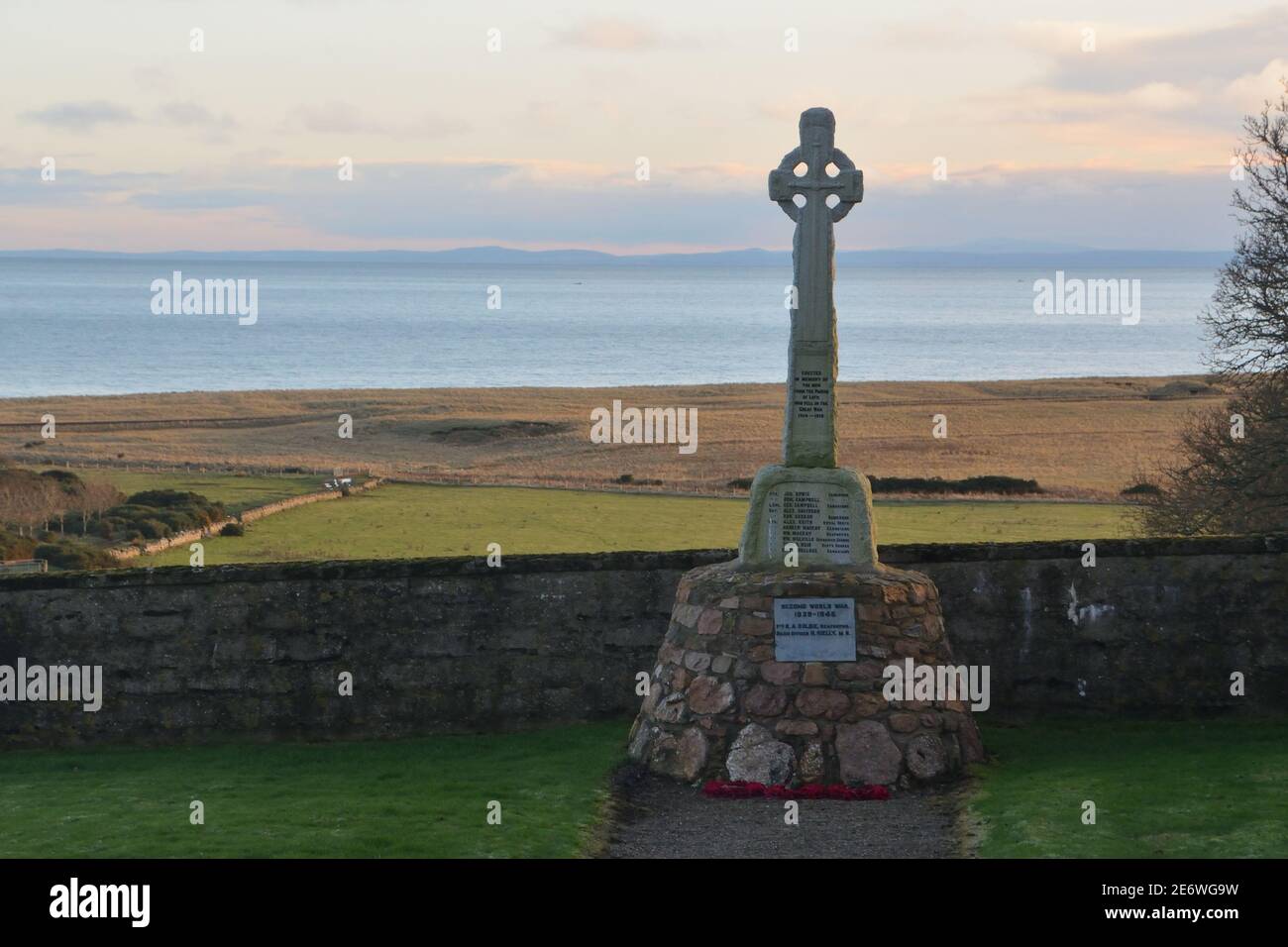 Ein Kriegs-Gedenkkreuz, das im Kirchhof von Lothmore steht und den Moray Firth an der Ostküste Schottlands überblickt. Stockfoto