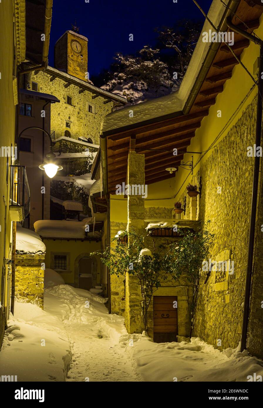 Die Stadt Rocca Pia nach einem starken Schneefall von den gelben künstlichen Lichtern beleuchtet. Stockfoto