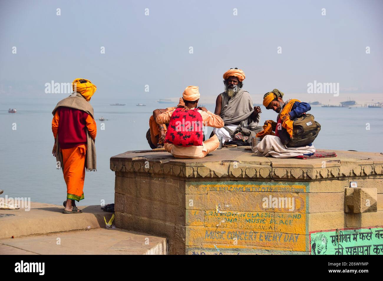Indische Männer auf den Ghats mit Blick auf den Ganges Fluss, Varanasi, Indien Stockfoto