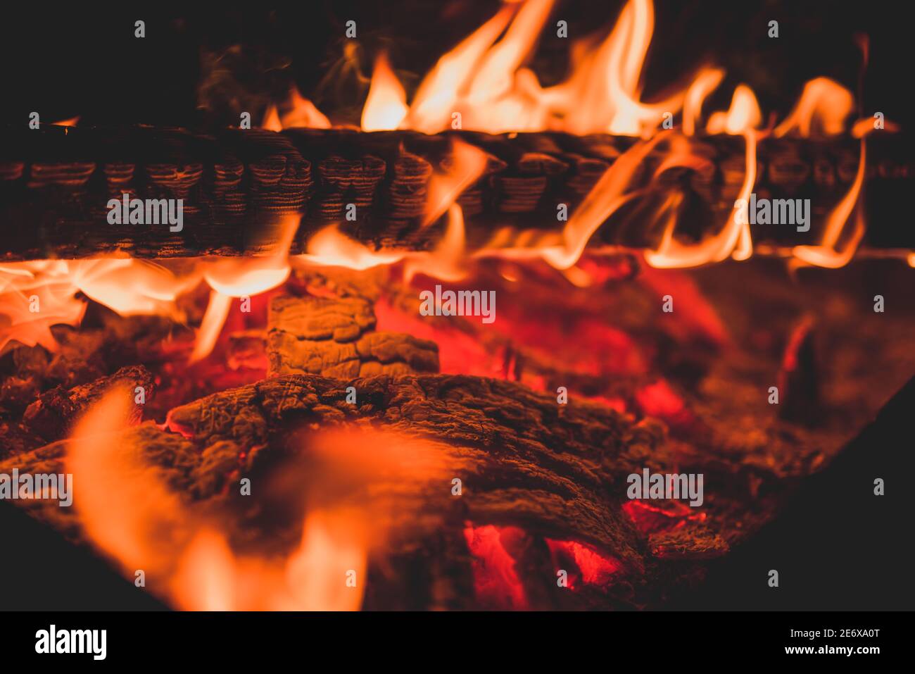 Nahaufnahme von brennendem Holzbalken als abstrakter Hintergrund. Die heiße Glut des brennenden Schwelbrands. Stockfoto
