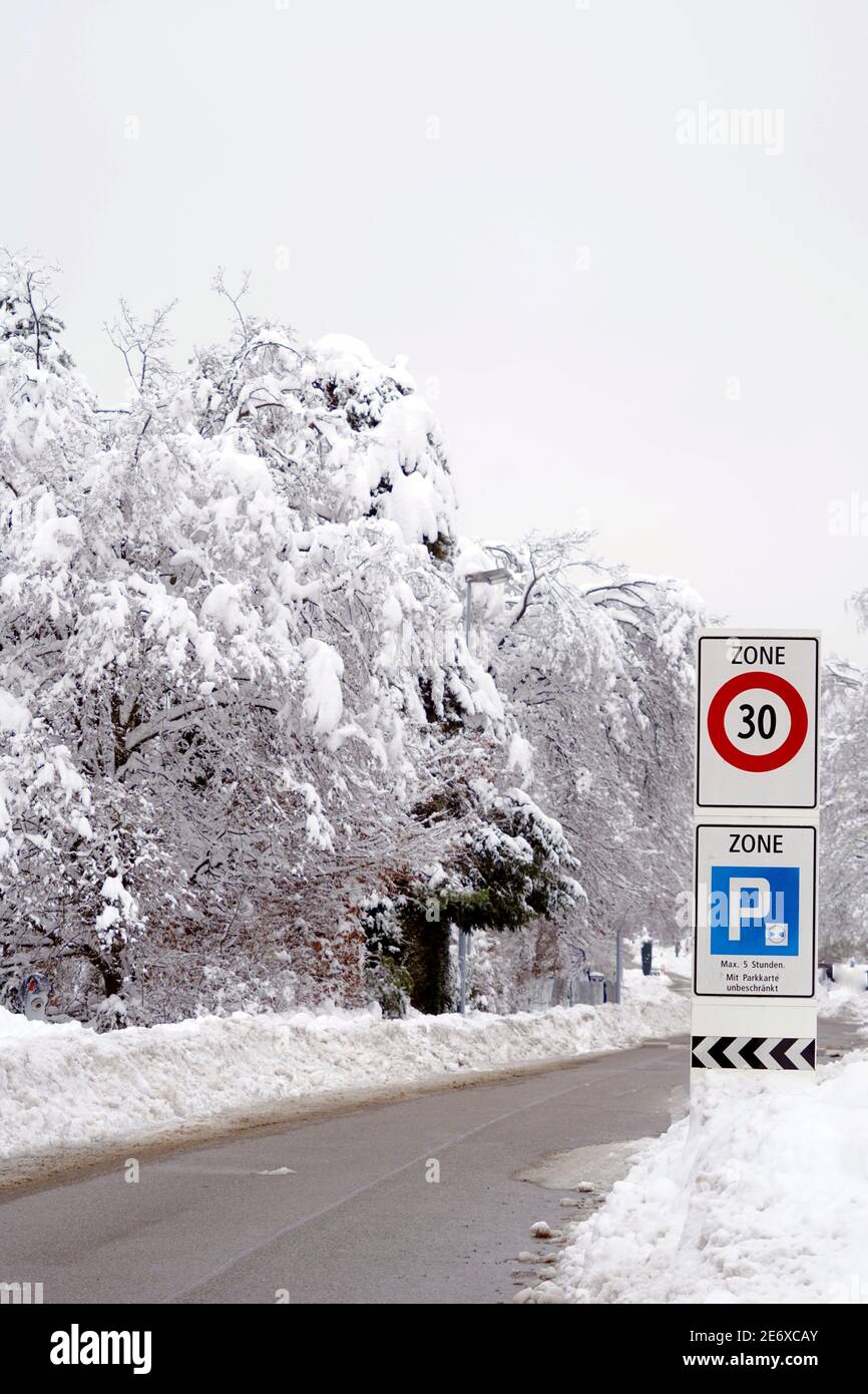 Winterstraße mit Verkehrszeichen für 30 km Geschwindigkeitsbegrenzung und Schild für Parken, sagen in Deutschland Parken ist erlaubt bis zu 5 Stunden oder unbegrenzt. Stockfoto