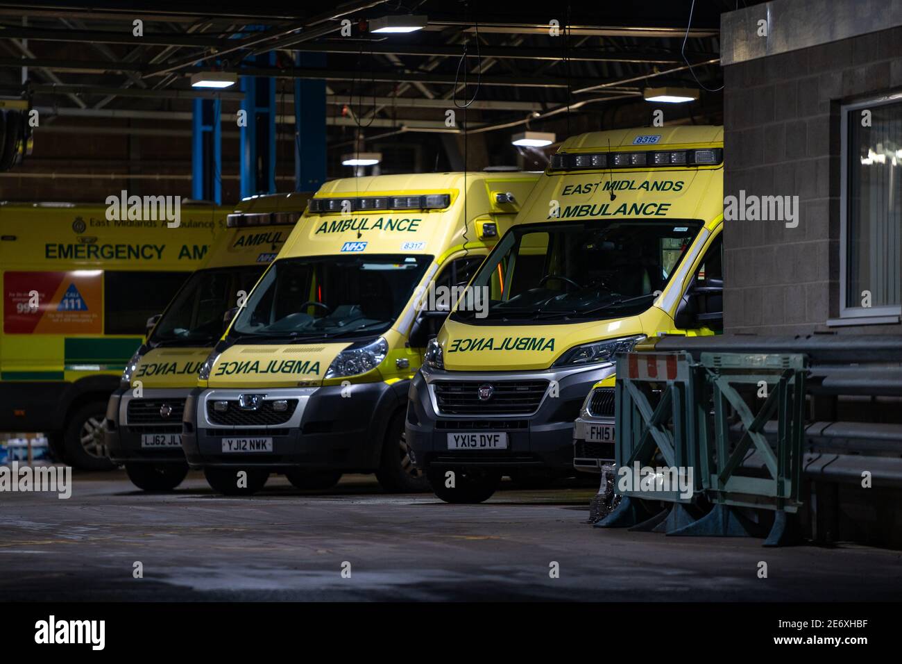 NHS Ambulance Station mit Flotte von sauberen Krankenwagen geparkt warten Für Notfallmaßnahmen bei Unfällen und Notfällen während einer Pandemie Blau Stockfoto