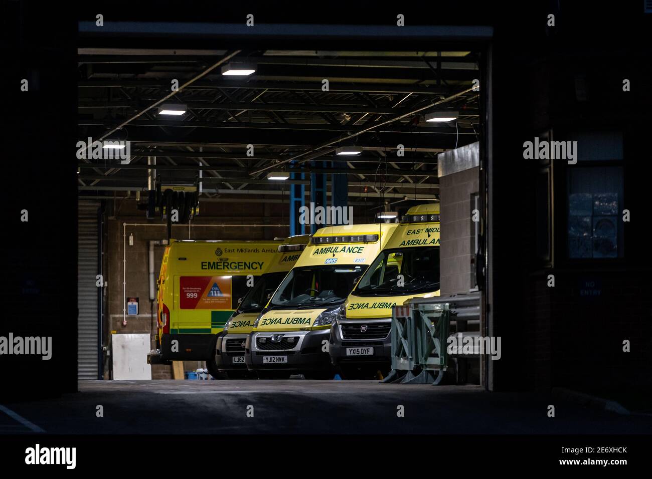 NHS Ambulance Station mit Flotte von sauberen Krankenwagen geparkt warten Für Notfallmaßnahmen bei Unfällen und Notfällen während einer Pandemie Blau Stockfoto