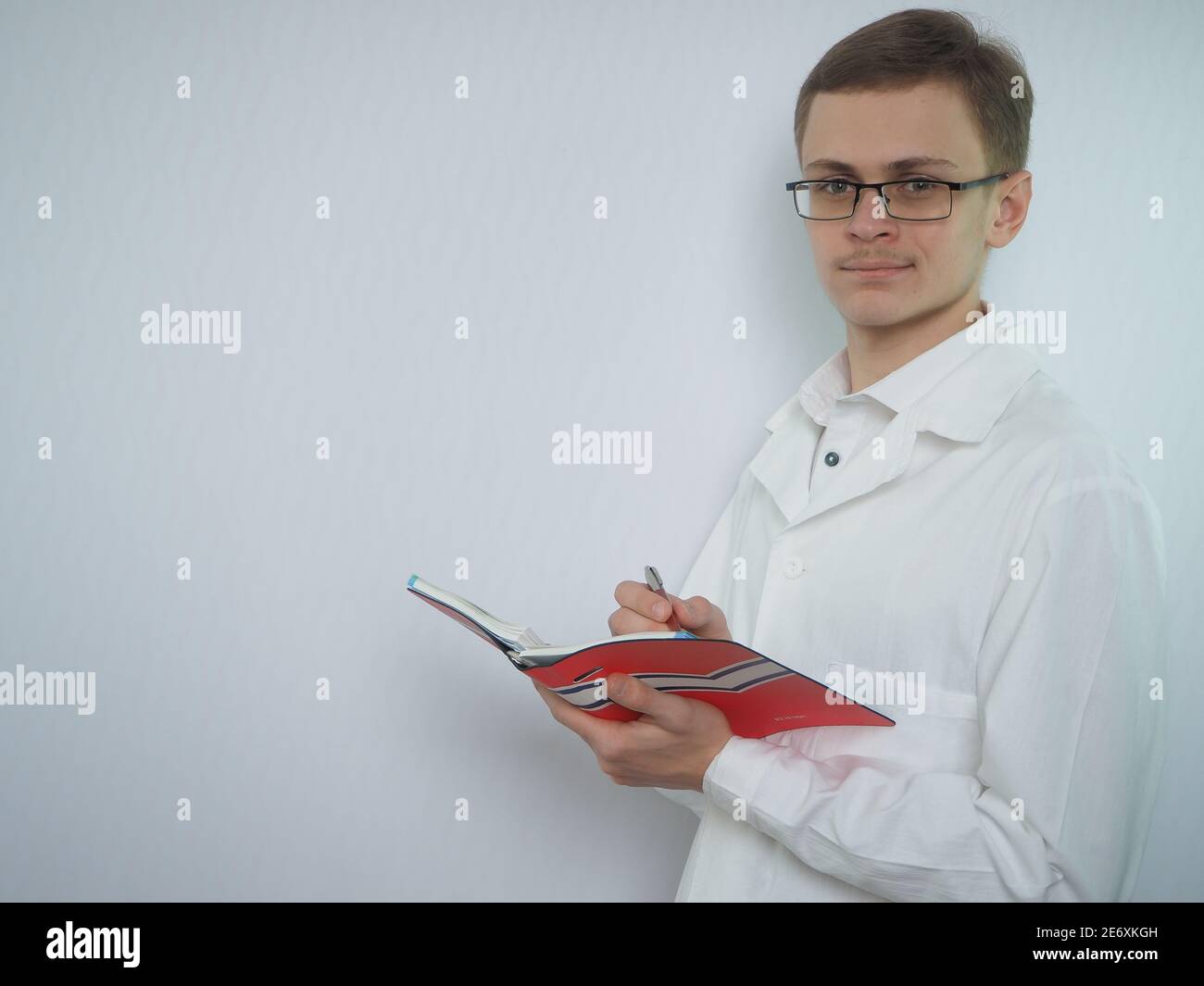 Porträt eines jungen Mannes mit europäischem Auftritt in medizinischer Kleidung. Ein junger Arzt oder ein Medizinstudent. Stockfoto