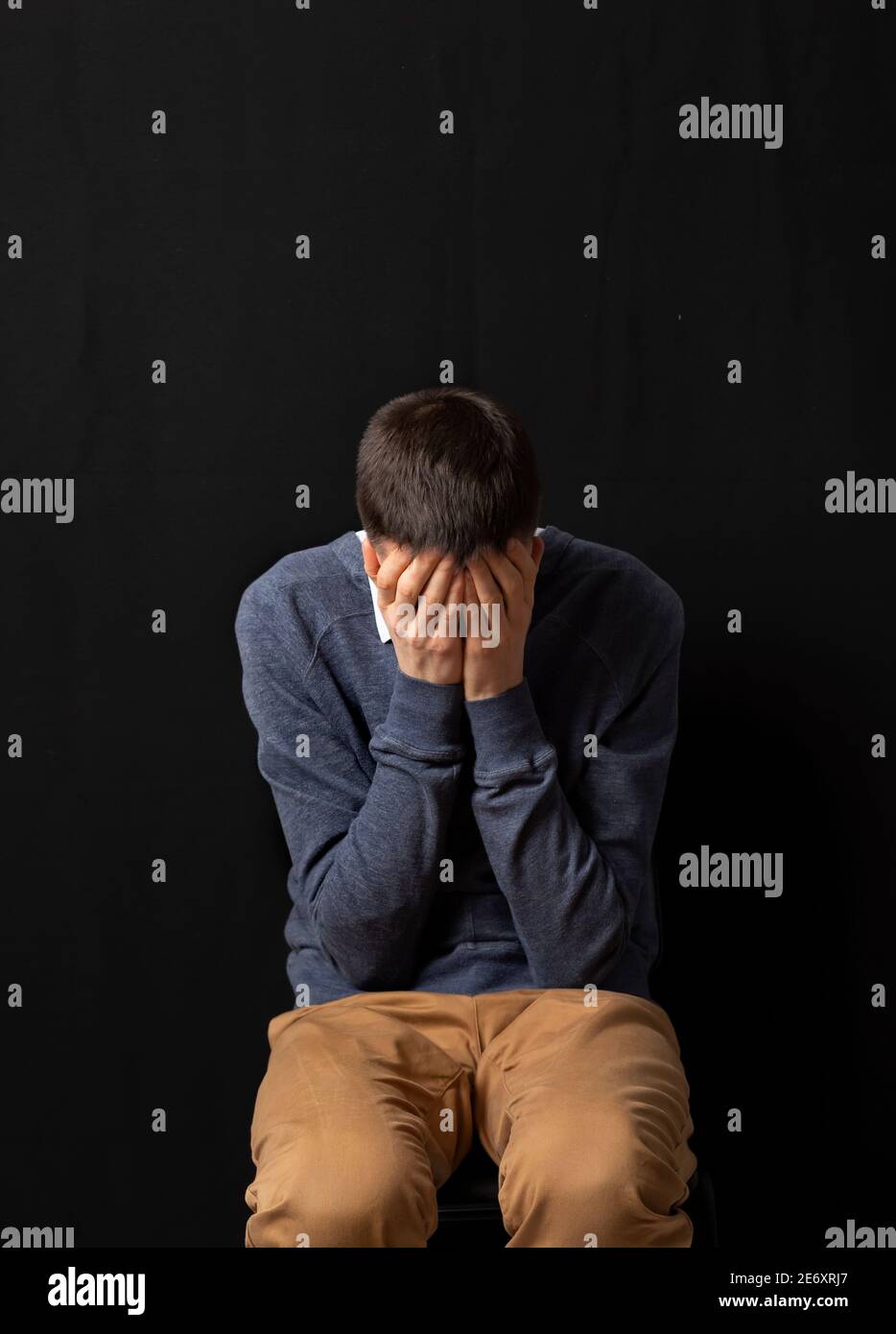 Psychische Gesundheit. Ein Mann in einem deprimierten Zustand auf einem schwarzen Hintergrund. Trauriger Mann. Stockfoto