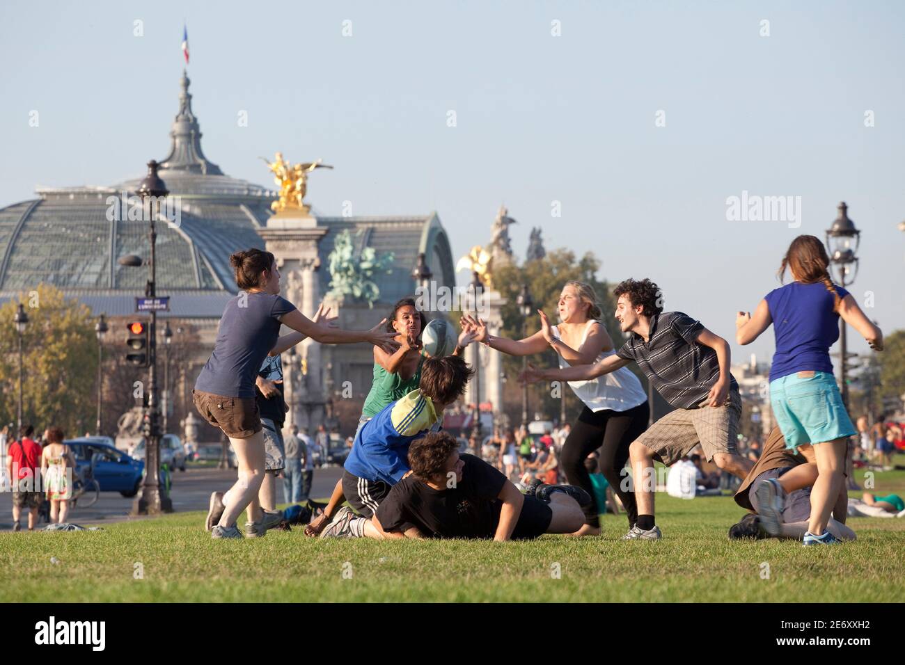Junge Leute auf einer Wiese mit dem Grand Palais im Hintergrund. Stockfoto