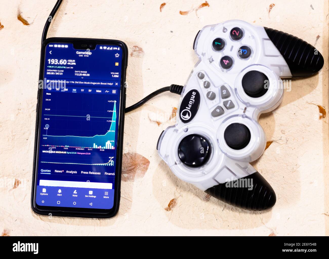 Kathmandu, Nepal - Januar 29 2021: Smartphone mit Aktienhandel-App zeigt Aktienkurs von GME gegen Gaming-Controller. Stockfoto