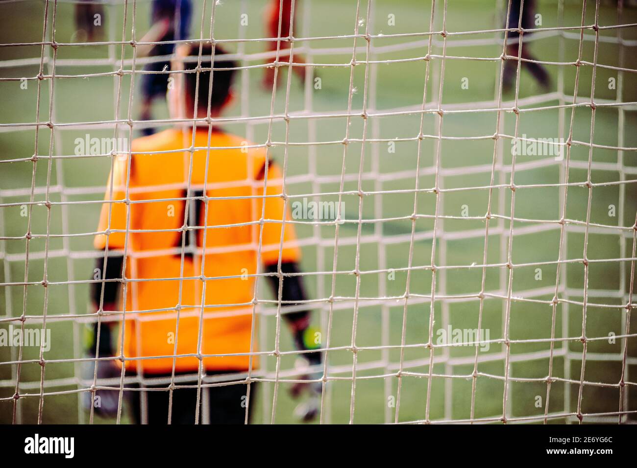 Selektiver Fokus eines Fußballnetzes mit dem Torwart aus Hinter Stockfoto