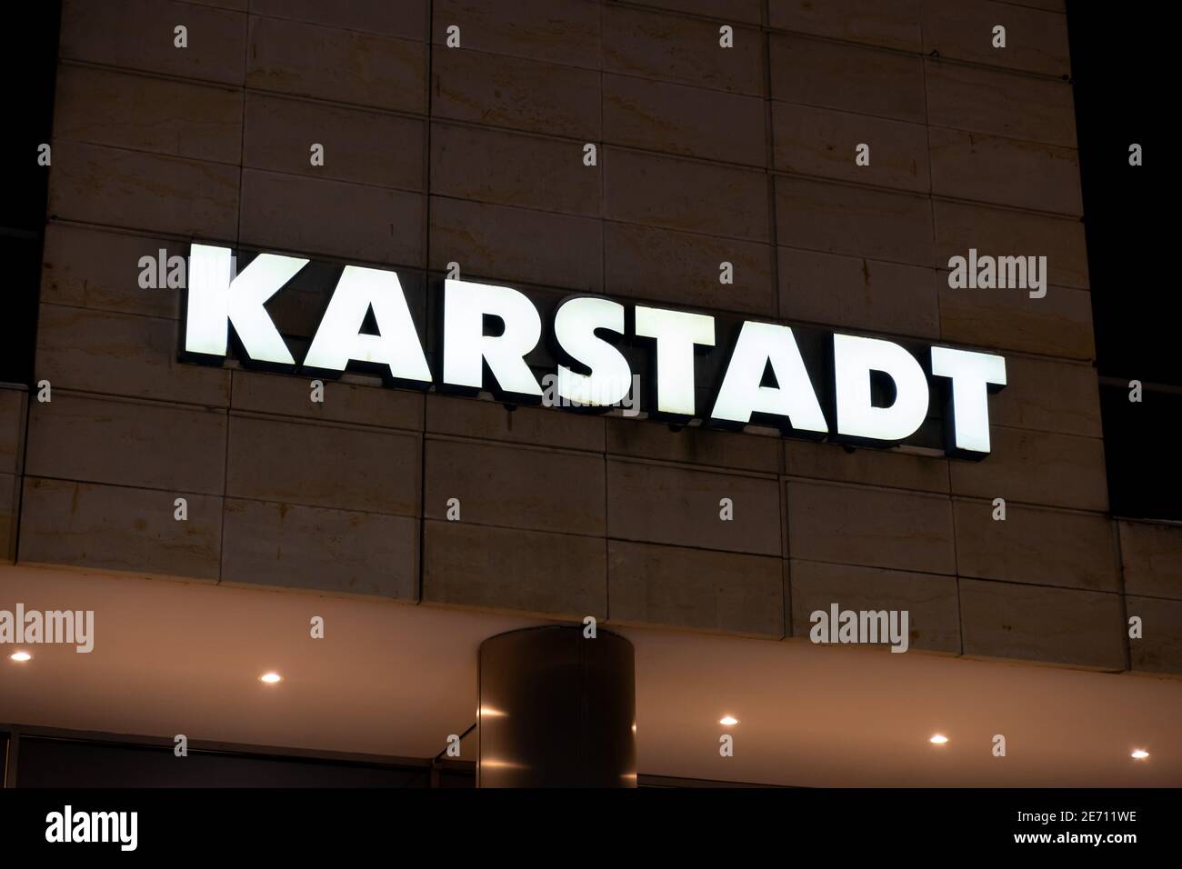 Galeria Karstadt Kaufhof Logo auf einem in weißem Licht beleuchteten Gebäude. Einkaufszentrum in Deutschland. Fassadengestaltung eines großen Einkaufszentrums. Stockfoto