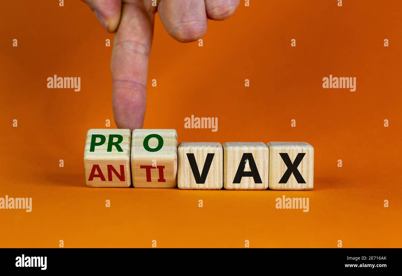 Pro-vax- oder Anti-vax-Symbol. Der Arzt dreht einen Würfel, ändert die Worte „Anti-vax“ in „Pro-vax“. Schöner orangefarbener Hintergrund. Speicherplatz kopieren. Business, medizinische Kov Stockfoto