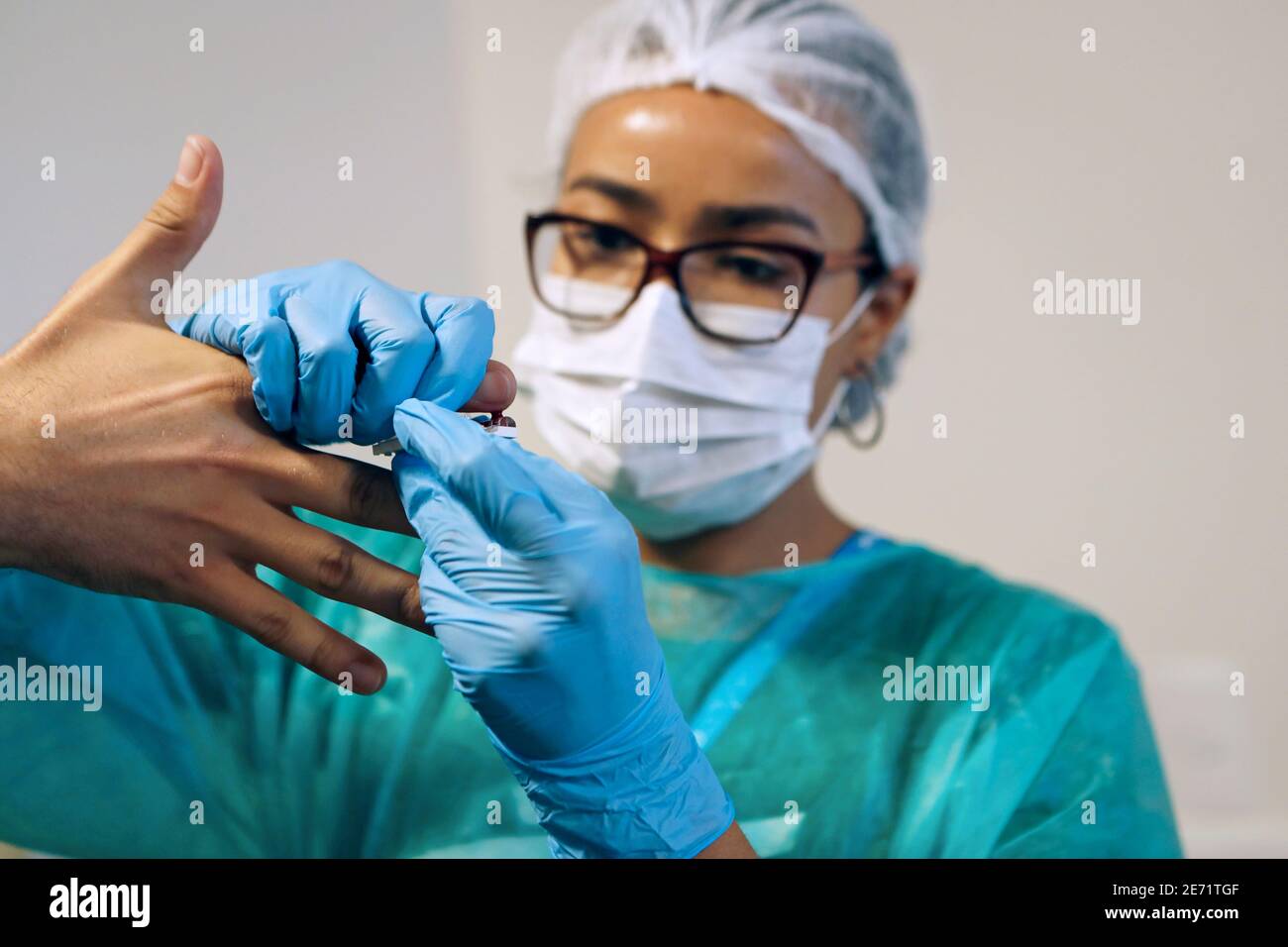 Blutuntersuchung von Krankenschwester mit blauen Latexhandschuhen, chirurgische einheitliche Schutz Gesichtsmaske. Erkennt Virusinfektion, Diabetes-Krankheit Anti-Doping Stockfoto