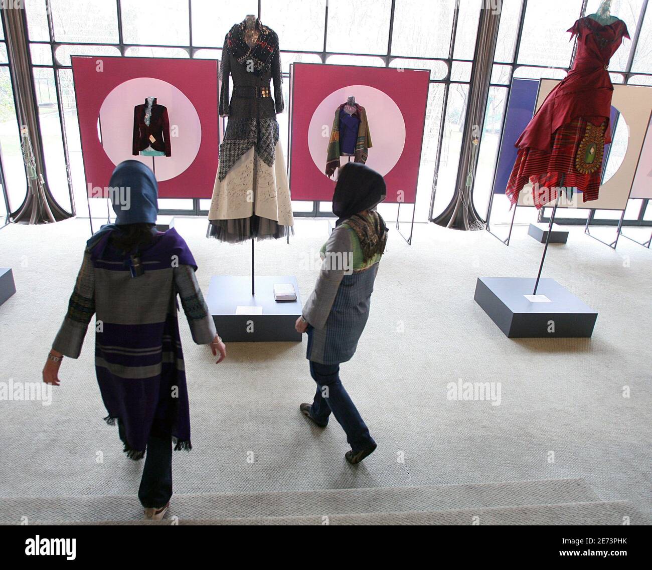 Die iranischen Models Mahsa (L) und Sanaz (R) beobachten am 14. März 2007 auf einer Fashion expo im Sadabad-Palast in Teheran lokal entworfene Kreationen, die gemäß den iranischen Kleiderregeln eine farbenfrohe Kleidung anbieten sollen. Im Iran, wo alle Frauen ihre Körperformen verbergen und den Kopf bedecken müssen, um die islamische Kleiderordnung zu beachten, fördert der Staat einen trendigen, aber islamisch korrekten 'TRO Chic', um Frauen von westlicher Mode abzubringen. Der neue Modus, inspiriert von der langen Geschichte des Landes, ist auf einer Teheraner Modenschau zu sehen, die einen nationalen Stil fördern und eine alternative anbieten will Stockfoto