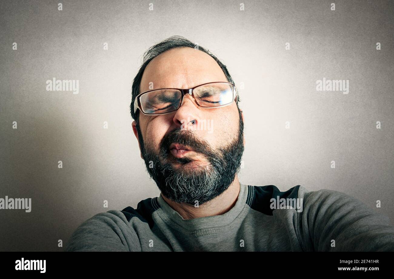 Lustiger Mann mit dem Bart, der Ausdrücke macht Stockfoto