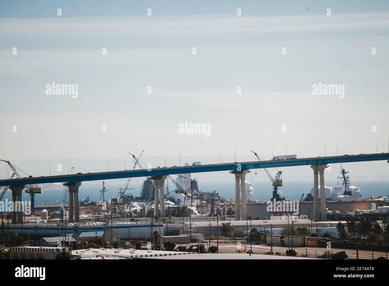 Ladekrane, die im Seehafen unter der Brücke arbeiten. Stockfoto