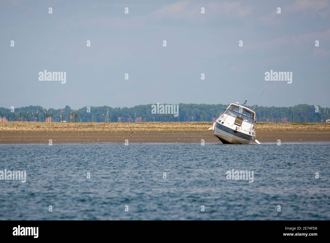 Motorboot in der Bucht von Arcachon, Gironde, Frankreich. Bei Ebbe kommen festverankerte Boote aus dem Wasser Stockfoto
