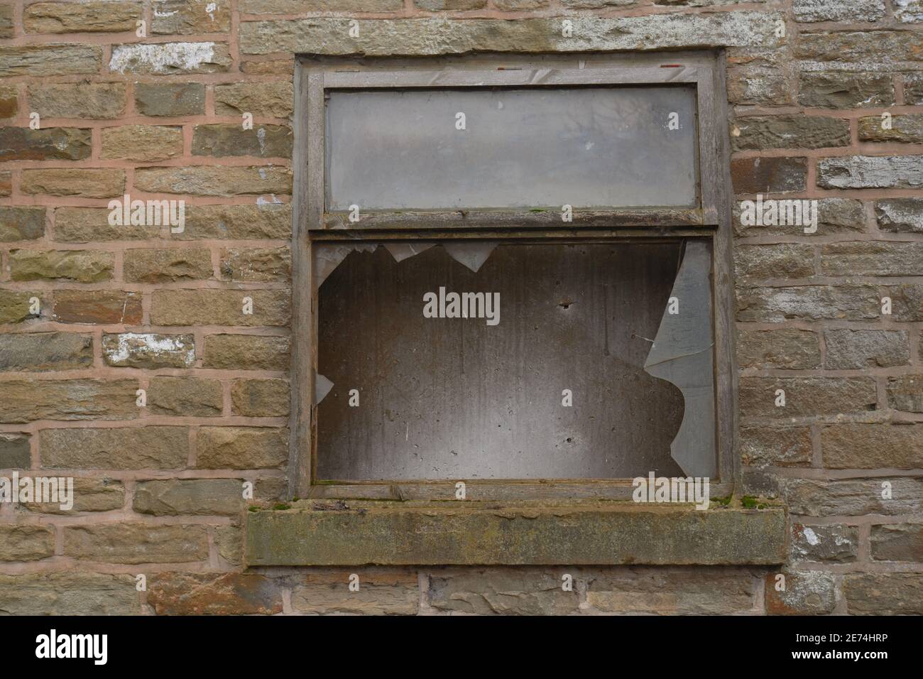 Alte Fensterrahmen mit gebrochenem Fenster auf einem alten Stein gebaut Bauernhof in England, Großbritannien genommen Stockfoto