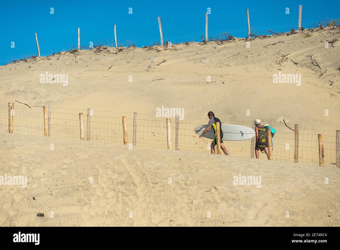 Mann mit Surfbrett verlässt den Strand mit seiner Familie Biscarrosse.Biscarrosse Plage ist ein wichtiges Surfziel am Atlantik Meer in Frankreich Stockfoto