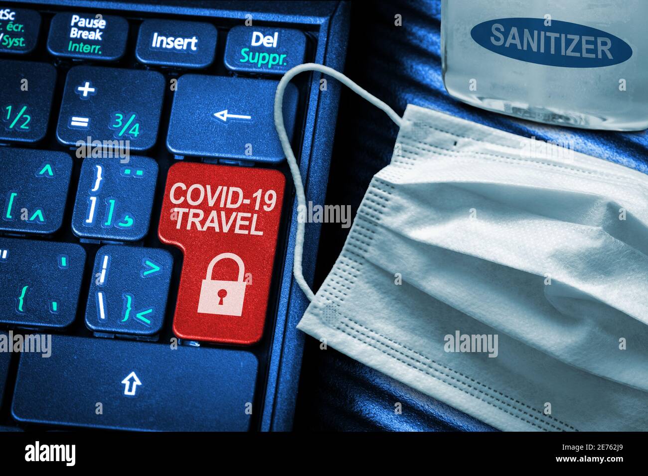 COVID-19 Coronavirus Reisebeschränkungen Konzept zeigt rote Taste Warnung auf der Tastatur mit medizinischen Gesichtsmaske und Handdesinfektionsmittel. Stockfoto