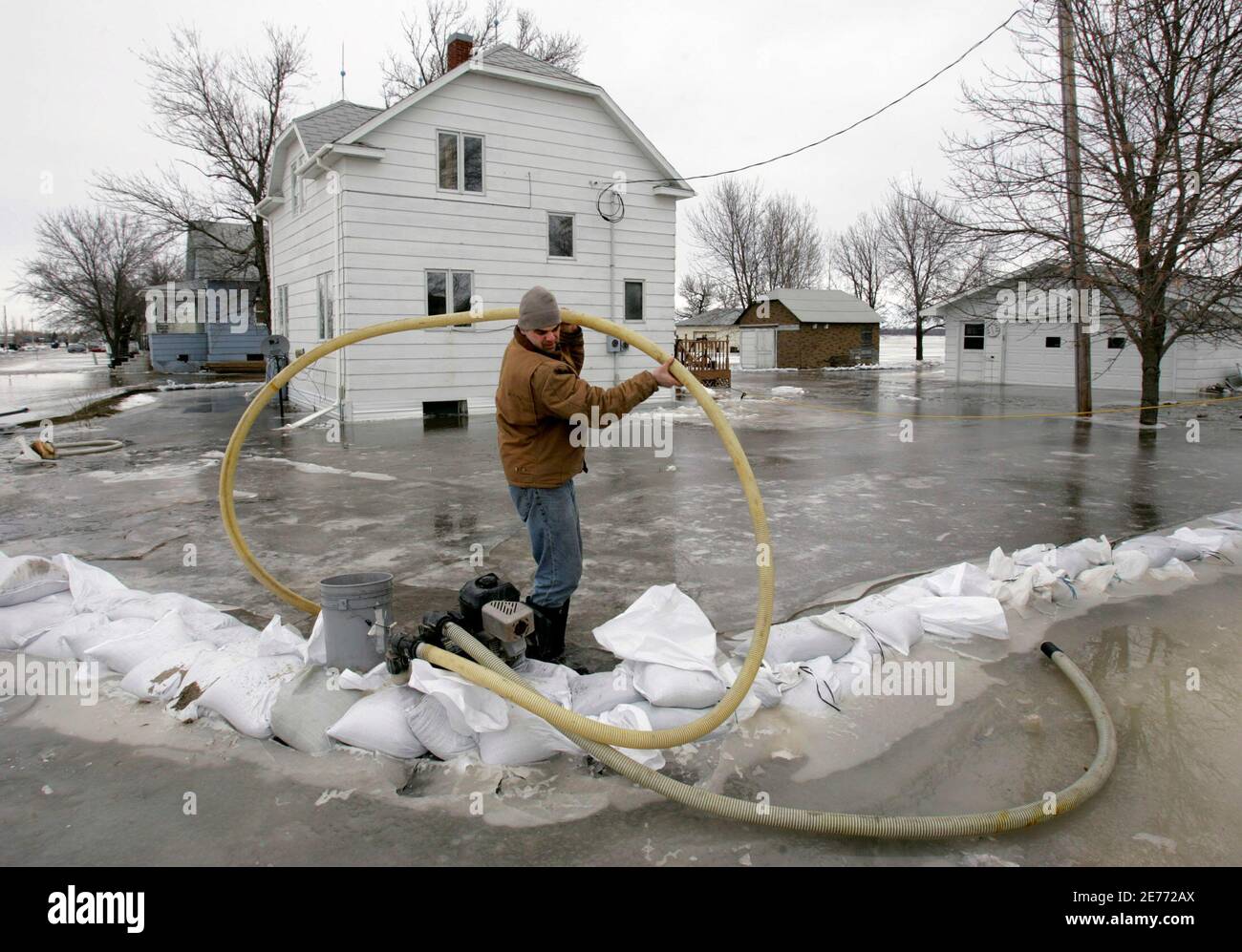 Justin Thompson versucht Wasser fließt durch eine Pumpe Schlauch als er  Schlachten Überland Überschwemmungen um seines Onkels Haus südlich von  Fargo, North Dakota, 29. März 2009. Ein Deich zurückhalten, geschwollene  Red River