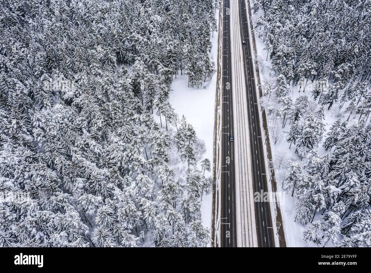 Gerade Straße durch die schönen schneebedeckten Waldlandschaften. Luftbild Stockfoto