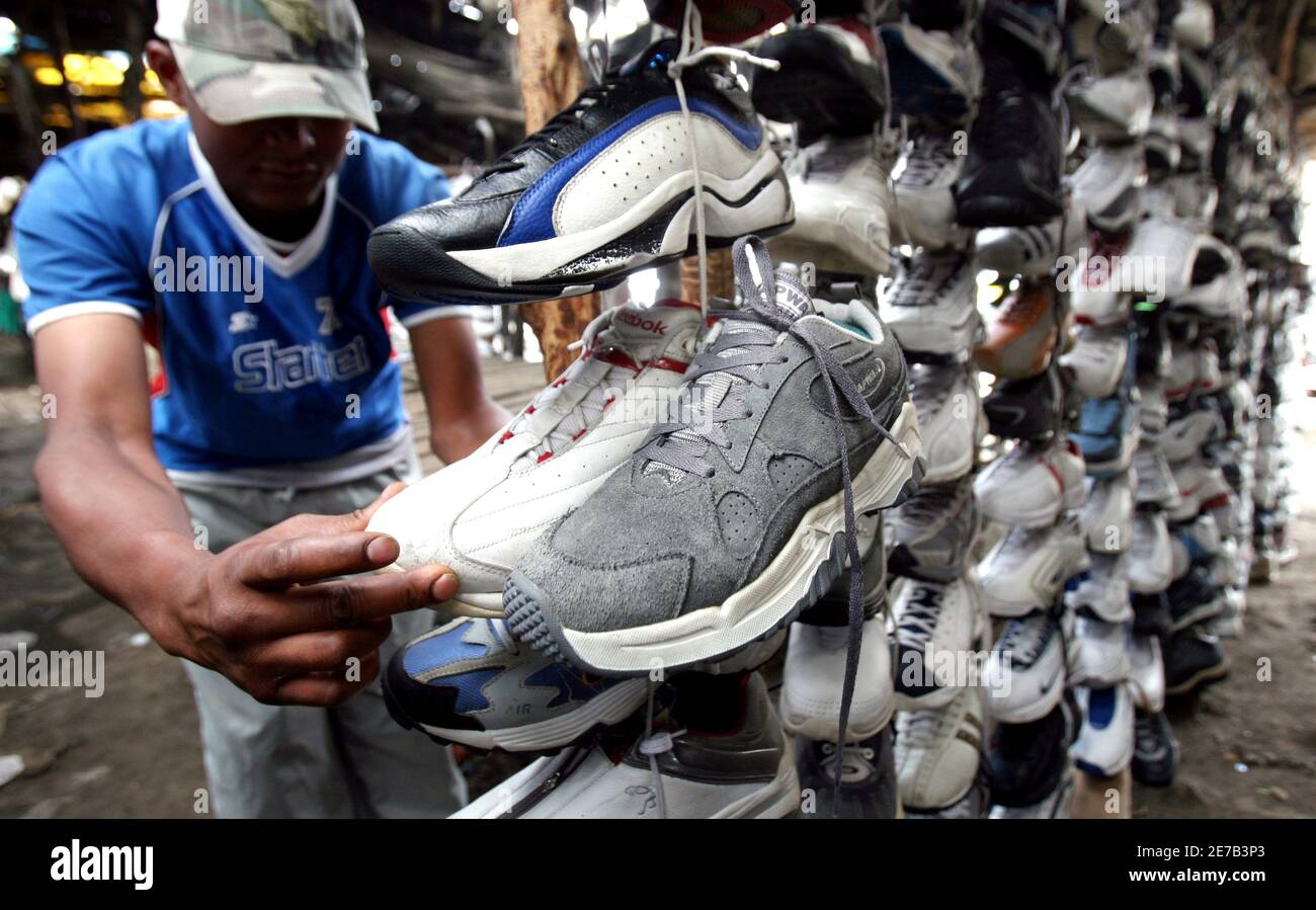 Ein Händler arrangiert Second-Hand-Schuhe zum Verkauf auf einem offenen Markt in Kenias Hauptstadt Nairobi, 3. April 2009. Der globale Konjunktureinbruch macht es für afrikanische Regierungen noch wichtiger, lokalen Unternehmen durch Bürokratieabbau in Bereichen wie Zoll, Steuern und Registrierung zu helfen, sagte eine kontinentale Investitionsbehörde am Freitag. REUTERS/Thomas Mukoya (KENIA) Stockfoto