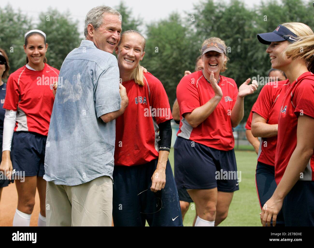 US-Präsident George W. Bush umarmt spielerisch US-Frauen Softball-Team Spieler Laura Berg im Fengtai Sports Center Softball-Feld bei den Olympischen Spielen 2008 in Peking, China, 9. August 2008.        REUTERS/Larry Downing (CHINA) Stockfoto