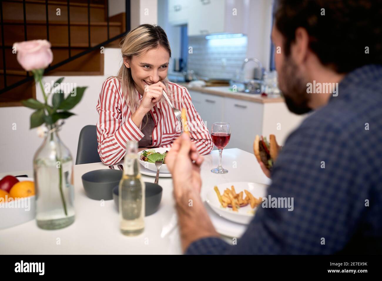 Ein junges Paar isst gerne zusammen in heimatlicher Atmosphäre. Zuhause, Küche, Essen, Beziehung Stockfoto